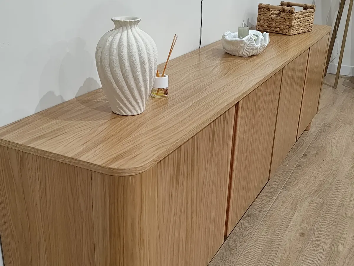 Mueble de TV bajo en acabado roble con encimera de esquinas redondeadas y puertas sin tirador